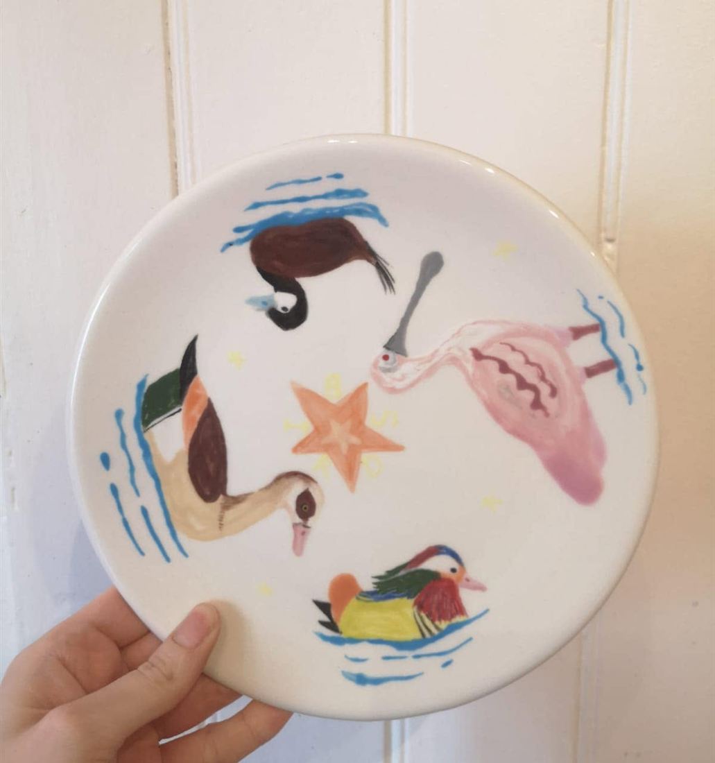 Plate painted with ducks and fish
